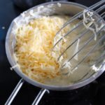 6. Do gotującego sosu dodać ser i wymieszać