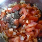 4. Dodać pokrojone pomidory do cebulki i doprawić solą i pieprzem